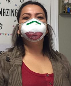 Mundy House employee Rosa Palma wearing a face mask big red lips drawn on the front.